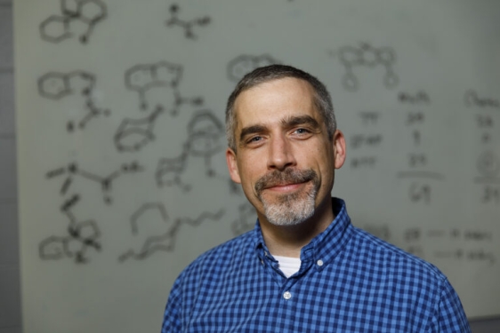 photo of man, chemical diagrams in background